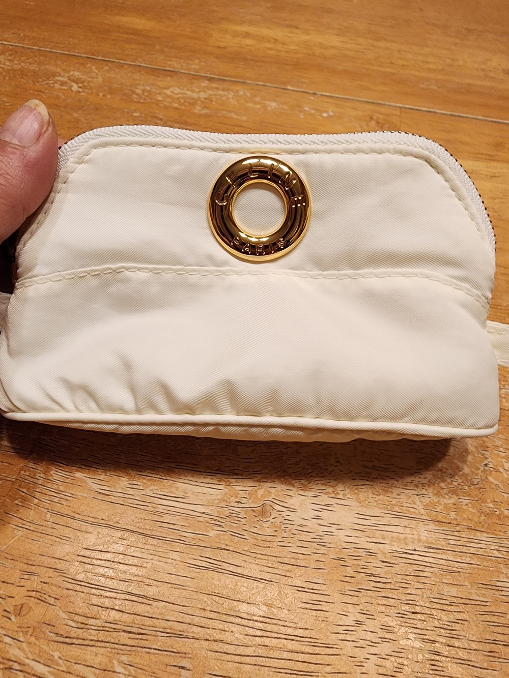 Celine nylon pouch features a prominent gold-tone circle logo hardware.